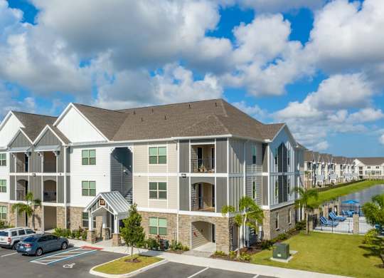 A large apartment complex with a parking lot in front at Mode at Melbourne, LLC Apartments, Florida