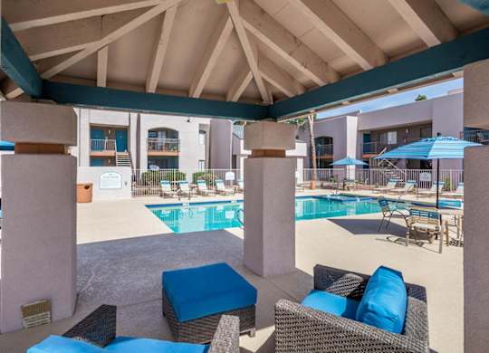 A pool area with a blue cushion and a black wicker chair.