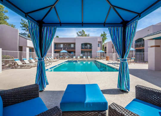 A pool area with blue furniture and a blue canopy.