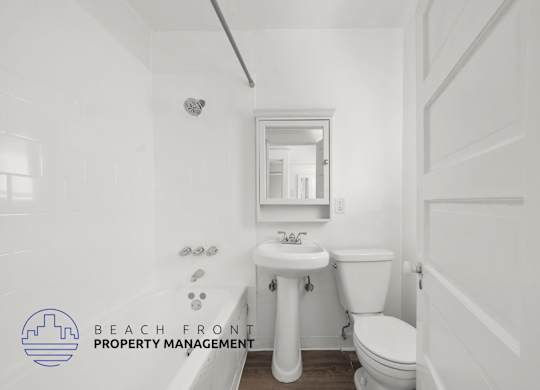 A white bathroom with a toilet, sink, and mirror.