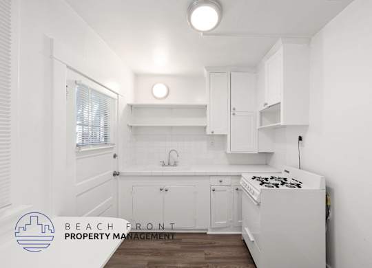 A kitchen with white cabinets and a stove top oven.
