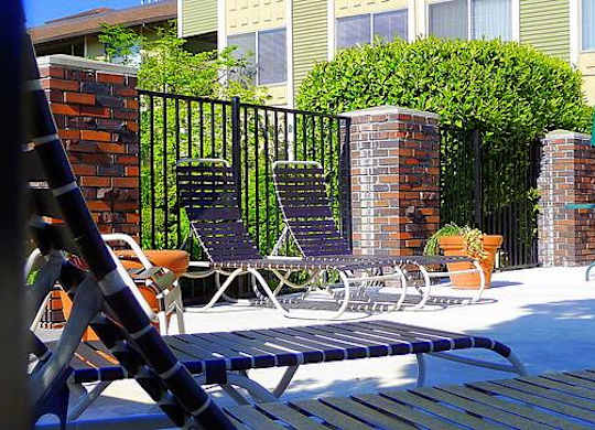 A pool area with chairs and a table.