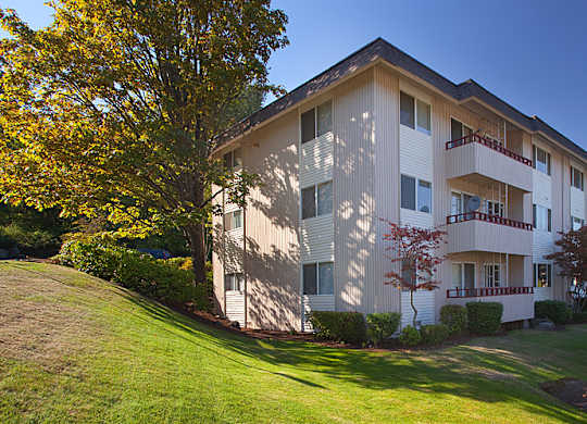 A large apartment building with a tree in front of it.