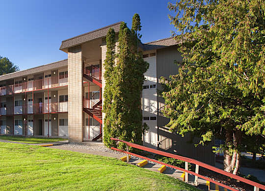 A large building with a red fence in front of it.