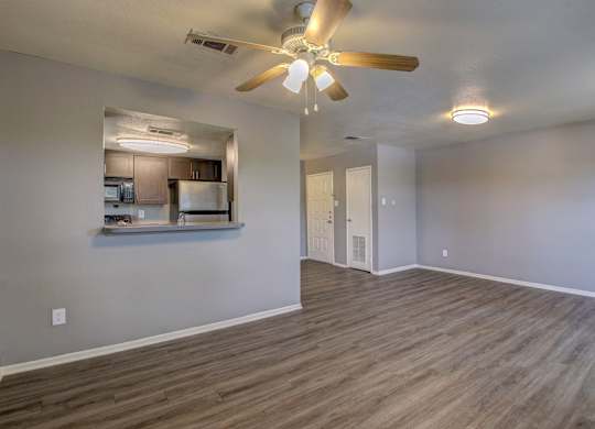 A room with a ceiling fan and wooden flooring.