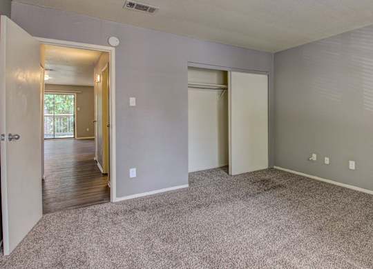 A room with carpeted floor and two doors.