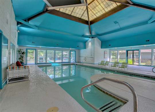A large indoor swimming pool with a wooden ceiling.