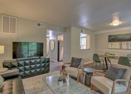 A modern living room with a glass table and leather couch.