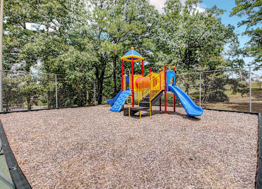 A playground with a blue and yellow slide.