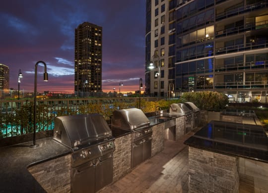 Outdoor grilling area at dusk with slight sunset and Kingsbury Plaza facade in the background at Kingsbury Plaza, Illinois