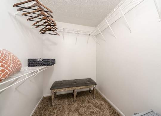 A small room with a bench and a coat hanger.