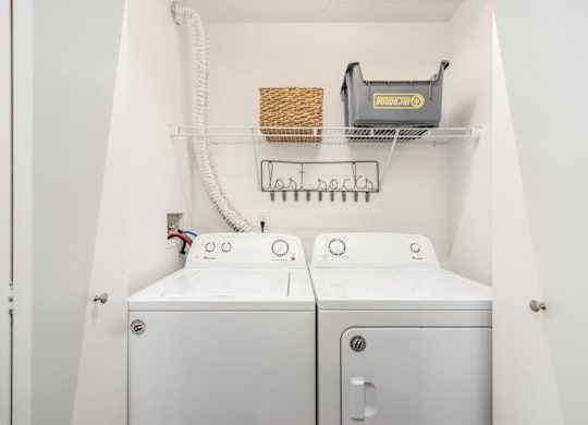 A white washing machine and dryer in a small laundry room.