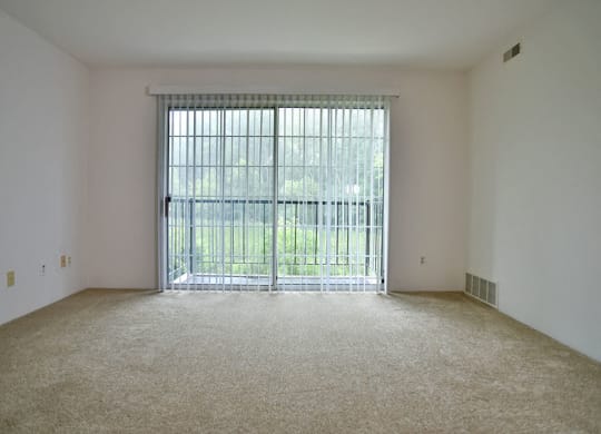 Living Room With Balcony Access at Charter Oaks Apartments, Davison, MI