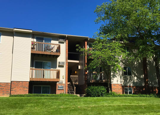 an apartment building with a green lawn and trees at Oakwood Apartments, Florence, KY, 41042