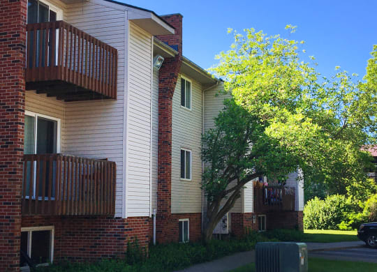 the outside of a building with a tree and a sidewalk at Oakwood Apartments, Florence, KY, 41042