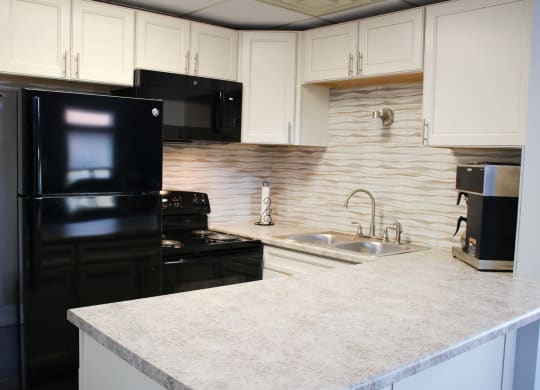 a kitchen with black appliances and a white counter top