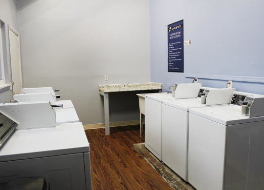 laundry room with white machines and a blue sign on the wall  at Concord Woods Apartments, Milford, Ohio