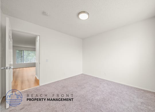 A room with a carpeted floor and a door leading to a balcony.
