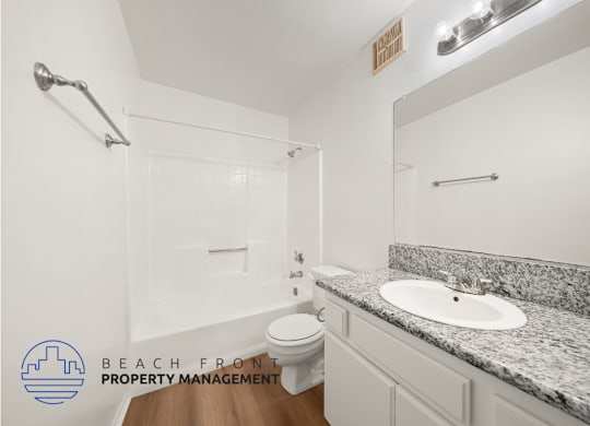 A bathroom with a granite countertop and a white sink.