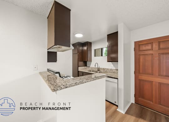 A kitchen with a granite countertop and wooden cabinets.