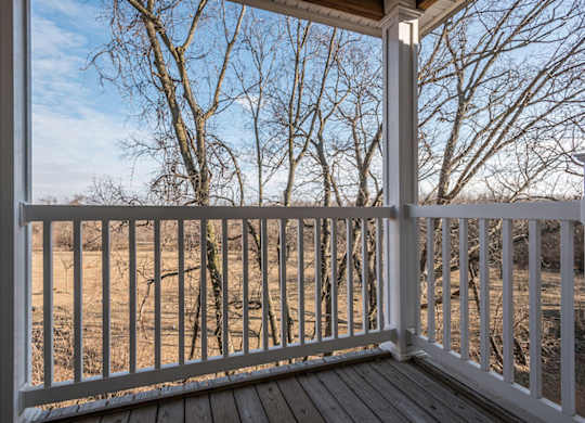 A view from a porch looking out to a wooded area.
