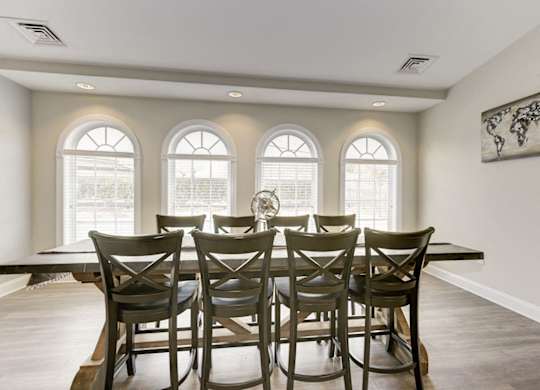 A dining room with a table and chairs.