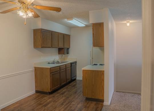 A kitchen with wooden cabinets and a ceiling fan.