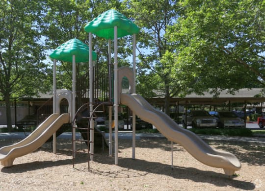 a playground with two slides and two umbrellas