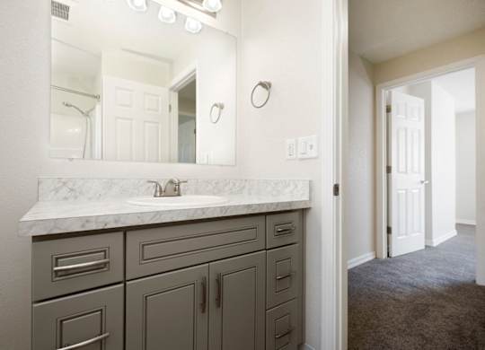 View of Bathroom Vanity with Grey Cabinets, Mirror, and Lighting at Woodlake Townhomes, Edmonds, WA