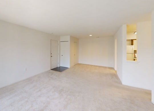 the living room and dining room of an empty home with white walls and flooring