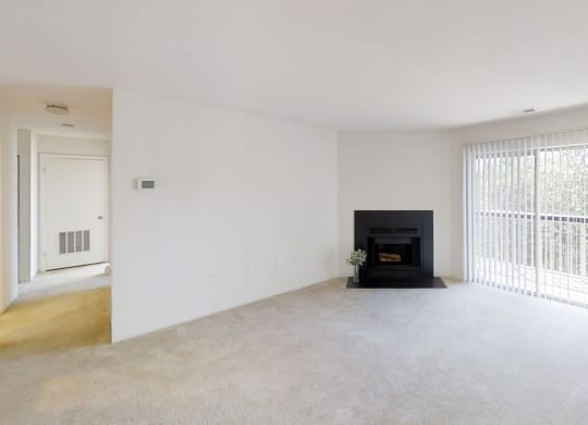 an empty living room with a fireplace and a window