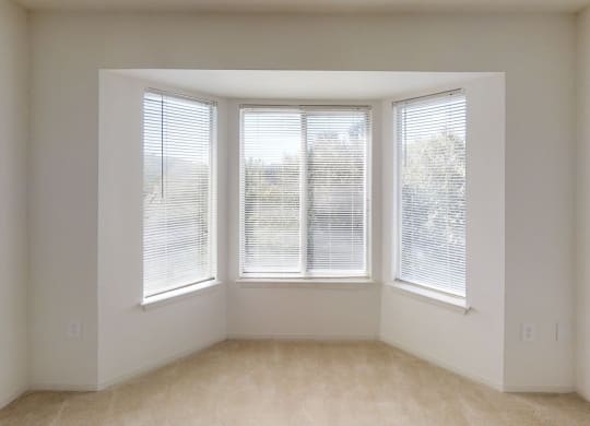an empty room with three windows in it