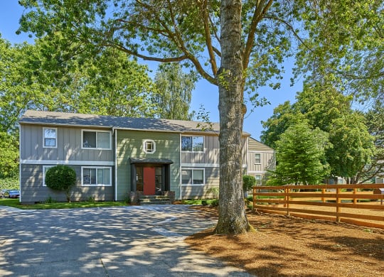 Exterior view of community. Shows a large tree along with wooded area.at Woodhaven, Everett