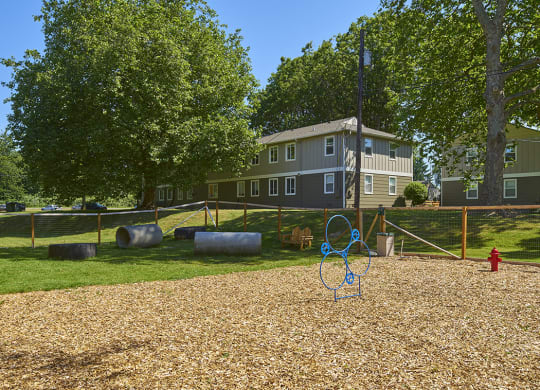 Pet park with training obstacles and wood chips outside of the community.at Woodhaven, Washington