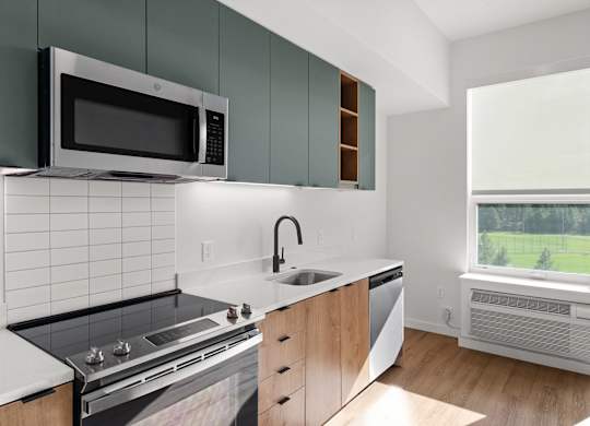 A modern kitchen with a black microwave above the stove.