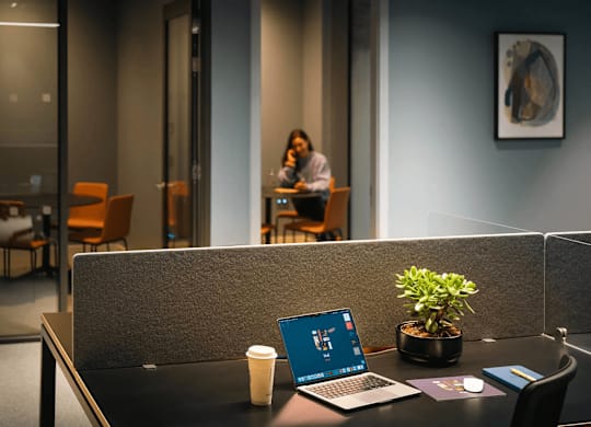 A laptop is open on a desk with a plant and a cup of coffee. at Cherrywood Apartments, D18 VY3V, DUBLIN 18