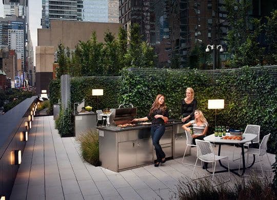 Two women are sitting at a table on a rooftop patio.