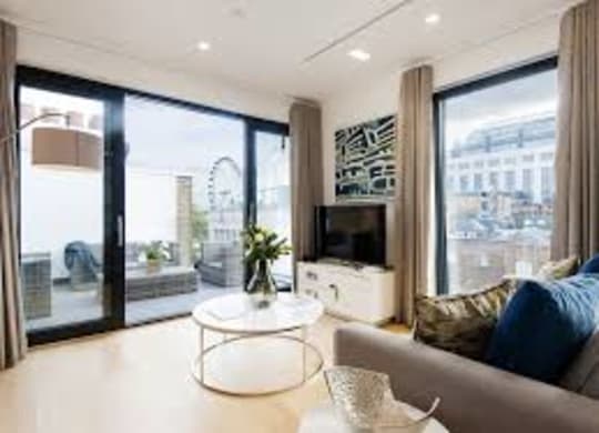 A modern living room with a grey sofa and a white coffee table.