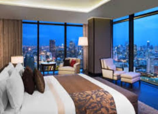 A bedroom with a large bed and a view of the city.