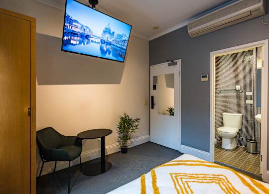 a hotel room with a bed and a tv on the wall