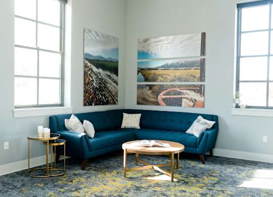a living room with a blue couch and pictures on the wall