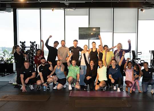 A group of people are posing for a photo in a gym at Cherrywood Apartments, D18 VY3V