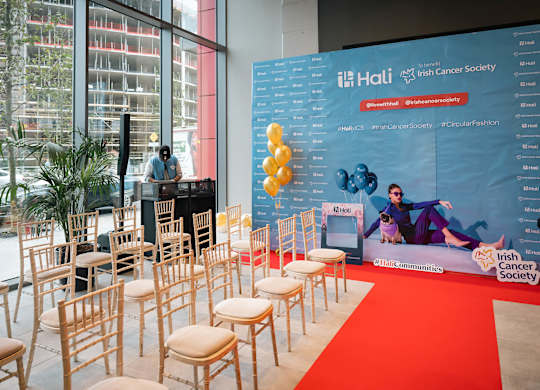 A row of chairs are set up in front of a banner for the Irish Cancer Society at Cherrywood Apartments, D18 VY3V