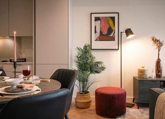 A dining room with a table set for two, a potted plant, and a framed artwork on the wall at Cherrywood Apartments, D18 VY3V, DUBLIN 18