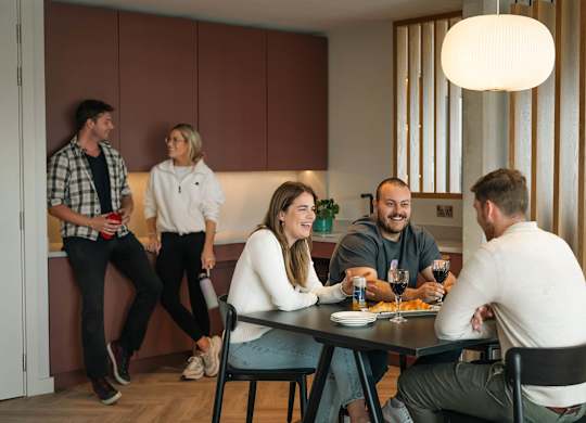 A group of people are gathered around a table eating and drinking at Cherrywood Apartments, D18 VY3V, DUBLIN 18