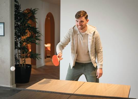 A man is playing ping pong in a room at Cherrywood Apartments, D18 VY3V, DUBLIN 18