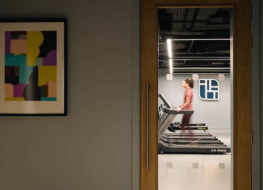 A woman is exercising on a treadmill in a room with a framed picture on the wall at Cherrywood Apartments, D18 VY3V, DUBLIN 18