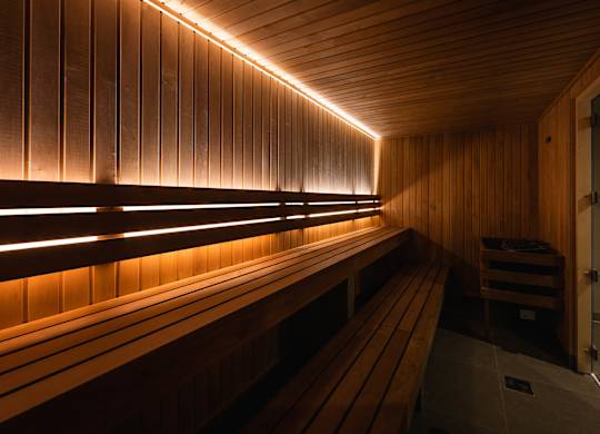 A sauna with wooden benches and walls, illuminated by a row of lights at Cherrywood Apartments, D18 VY3V, DUBLIN 18