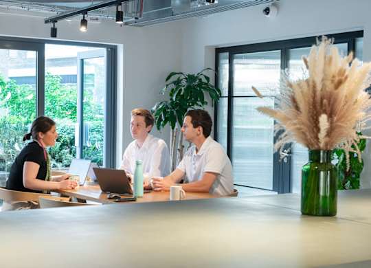 Three people sitting at a table in conference room at The Lark, London