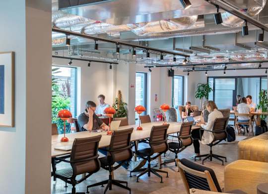 Co-working space with a long table and comfortable chairs at The Lark, London